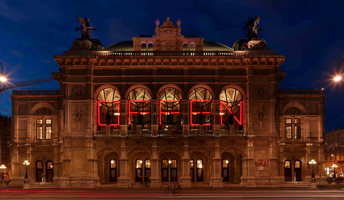 &raquo;<em>Offen</em>&laquo; &mdash; eine Installation des &Ouml;sterreichers Alexander Kada. &raquo;<em>Offen</em>&laquo;, eine tempor&auml;re Lichtinstallation auf der Fassade der Wiener Staatsoper, war urspr&uuml;nglich als visuelles Zeichen zum Beginn der neuen Saison gedacht. Eine Einladung an die Stadt; eine Einladung an alle. Durch <abbr>COVID-19</abbr> wuchs ihm eine neue und grundlegende Bedeutung zu: Im Haus am Ring werden seit 19.&nbsp;Mai&nbsp;2021 wieder Oper und Ballett gespielt. &copy; Wiener Staatsoper GmbH/Michael P&ouml;hn